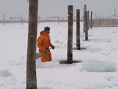 Bruce shovelling loose ice after chipping out the piling ice hole © 2006 ctLow